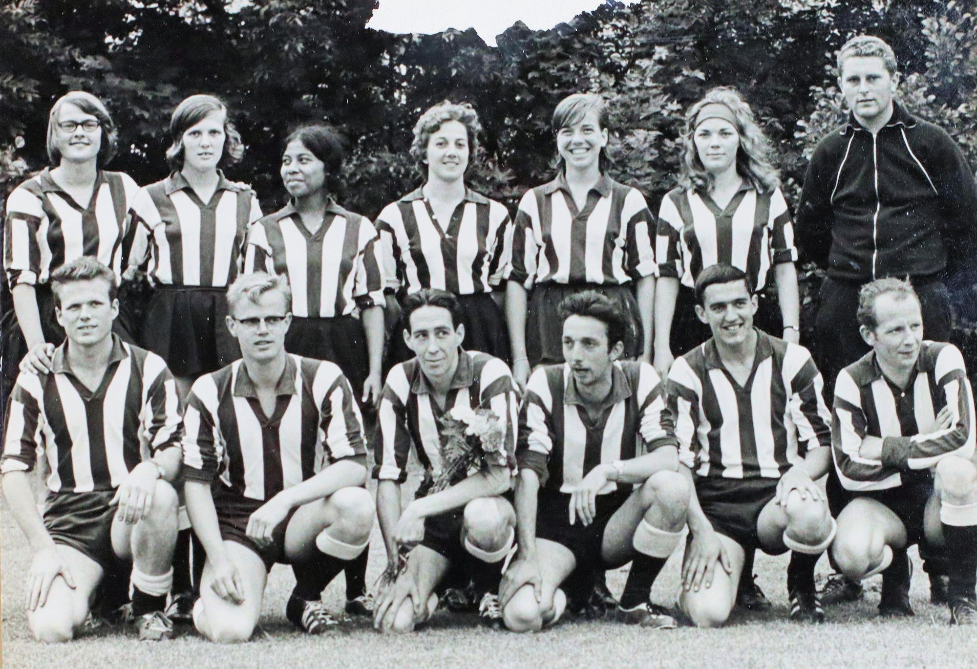 Een gemengd Animo-team in gestreepte shirts poseert op het veld in 1965.