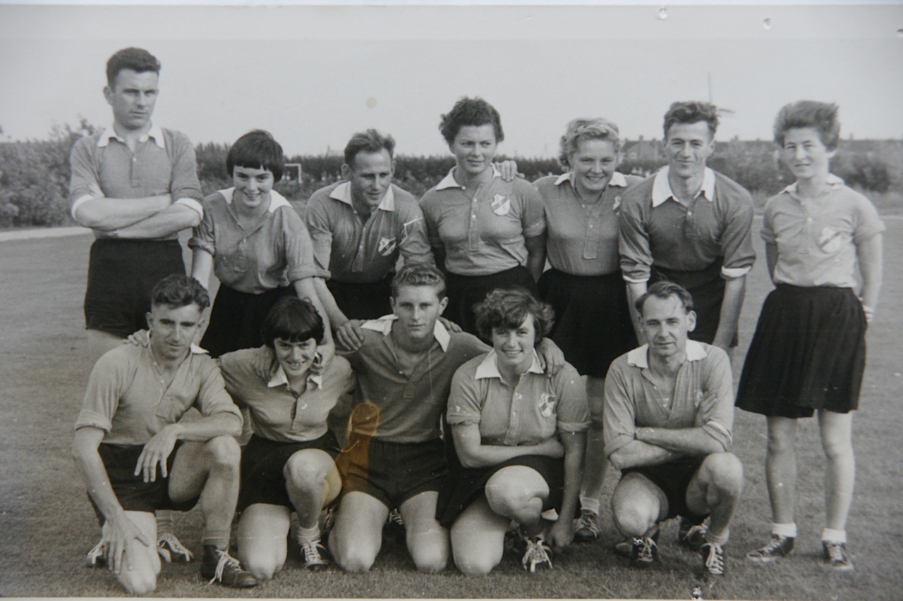 Een gemengd Zuidwesters-team in clubtenue poseert voor de foto.